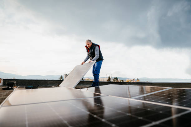 uomo che installa un sistema di pannelli solari fotovoltaici. tecnico che lavora con i pannelli solari. concetto ecologico di energia alternativa - procession panel foto e immagini stock