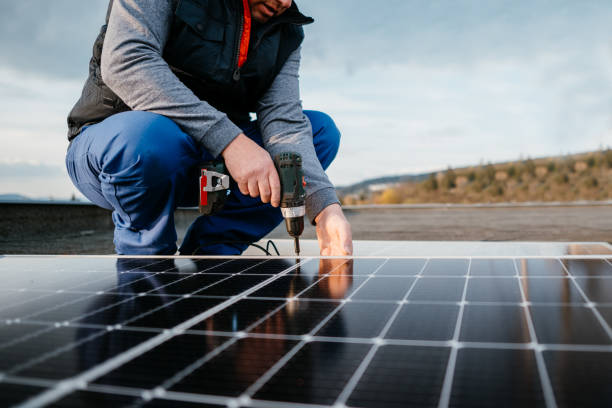 gros plan d’un technicien de l’énergie solaire. montage du module solaire bleu. eco concept d’énergie alternative - solar power station solar panel energy electrician photos et images de collection