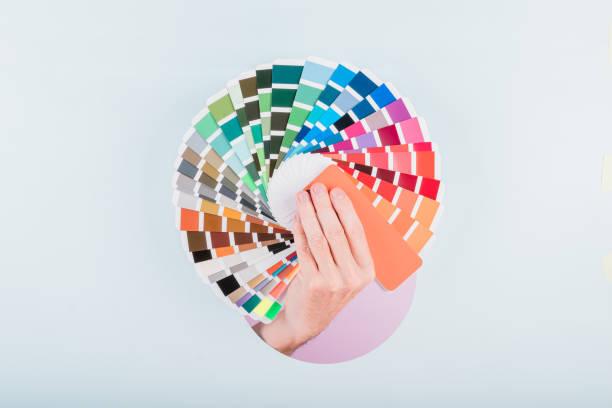 istock man hand holding a color guide palette on a blue background 1783303039