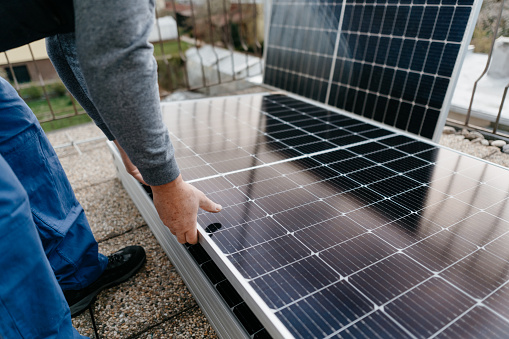 close up. man holds the solar panel and sets the correct position. Green energy concept. Copy space