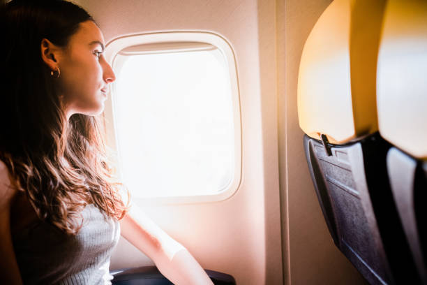 istock young girl looking through the window while traveling on airplane 1783327832