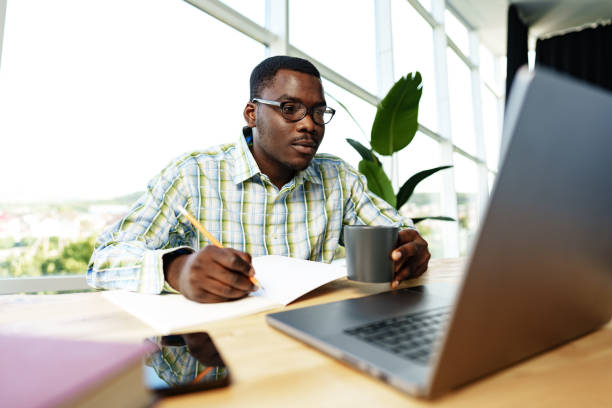 istock Serious concentrated african man studying or working with laptop indoors 1783335923
