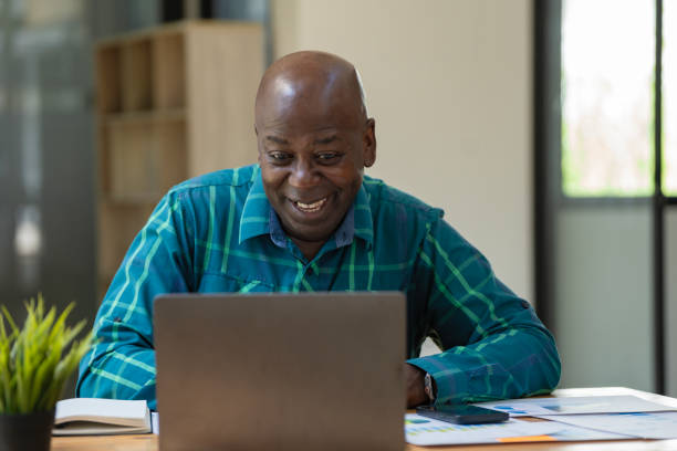 istock A senior black man is excited while using a laptop in an office. 1783343030
