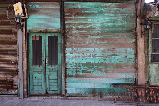 Old shop with green shutters and green doors