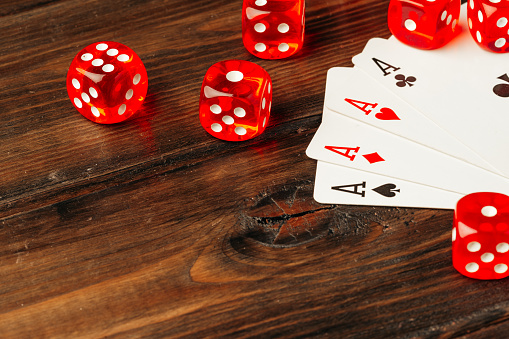 Playing cards and dice cubes on wooden background close up