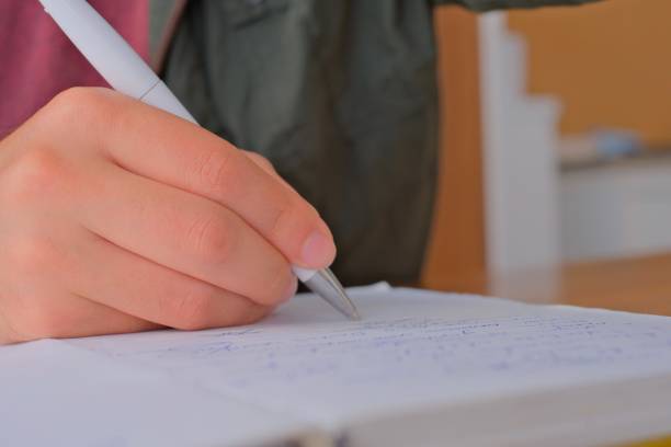istock Business woman hand is writing on notepad with pen in office. 1783380654