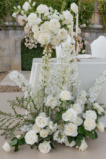 Luxurious floral arrangement of gorgeous white roses in front of bride , groom's table at ceremony.