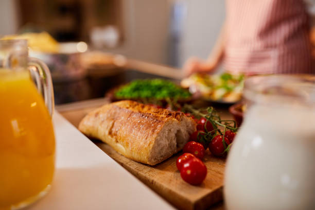 Close up of cherry tomatoes and fresh bread on cutting board in the kitchen.