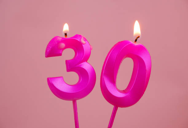 istock Pink birthday candles burning on pink, number 30. 1783417051
