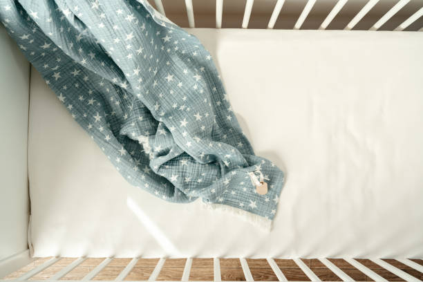 istock Soft blue muslin blanket hanging on a baby's bed 1783419317