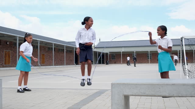 Small group of girls enjoying jump rope in the school yard