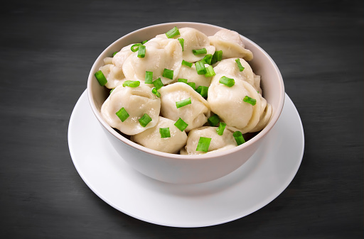 Steamed Asian Pork Dumplings in Chili Oil with Green Onions