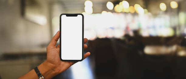 istock Woman hand holding mobile phone with blurred restaurant on background. Blank screen for your advertise design 1783459326