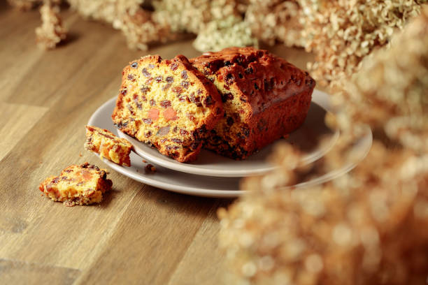 Cake with raisins and candied fruit. Fruit cake on a wooden table with dried flowers. Selective focus.