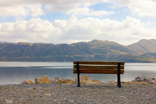 A bench with a mountain and sea view