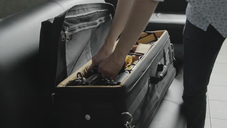 Professional cameraman arranges equipment in suitcase