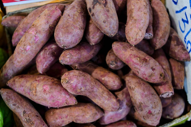 mucchio di patate dolci fresche alla bancarella del mercato - raw potato farmers market market stall vegetable foto e immagini stock