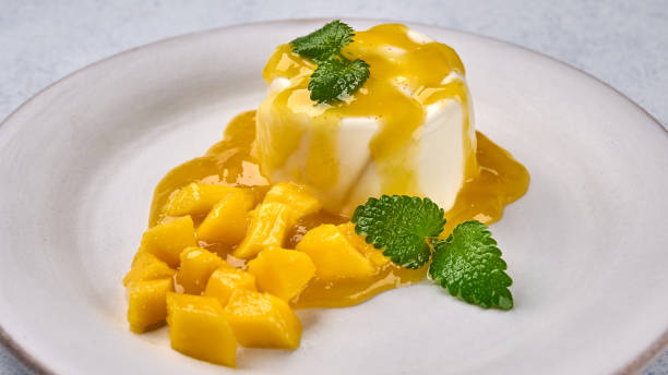 istock Panna cotta with natural vanilla pod, mango syrup and mint, high key, panoramic view 1783509507