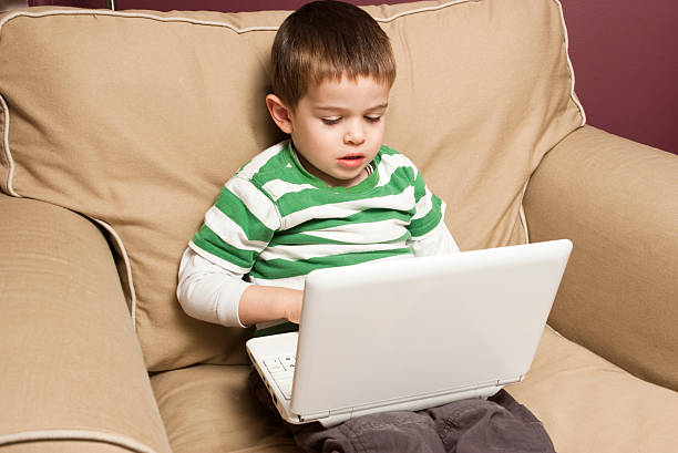 Young boy  using a netbook stock photo