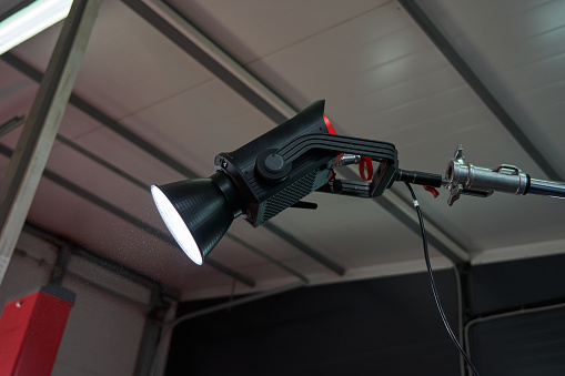 working professional lighting device monopod on the set installed under the ceiling of the room
