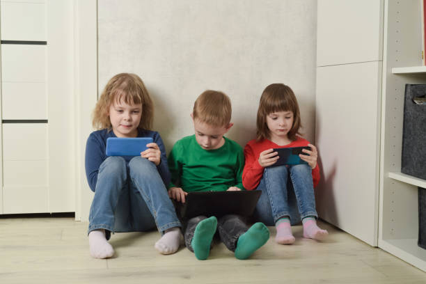 istock Children sit on the floor and use electronics to learn, play and communicate. 1783549052
