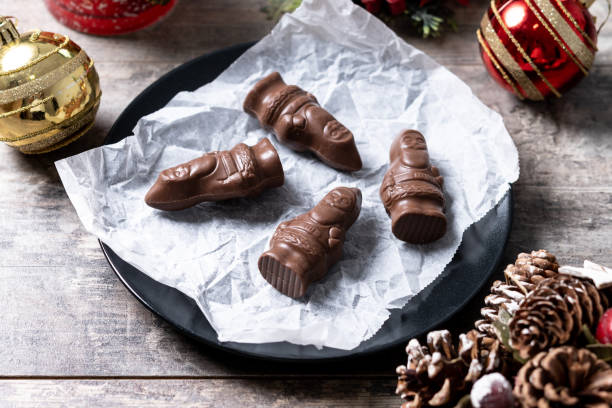 Close-up de um alegre Papai Noel de chocolate embrulhado na mesa de madeira - foto de acervo