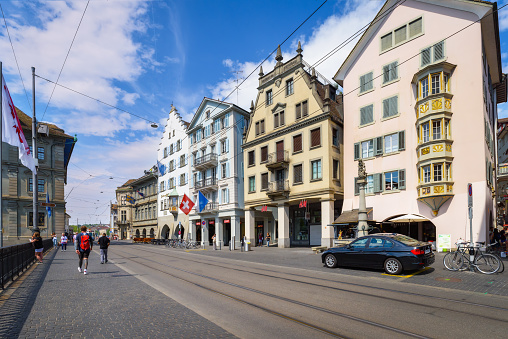 Zurich, Switzerland - June 18, 2023: Cityscape of downtown Zurich with Limmat river embankment on a clear sunny day with blue sky. A walk through the city.