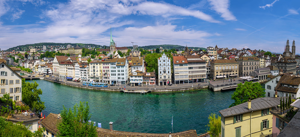 Zurich, Switzerland - June 18, 2023: Cityscape of downtown Zurich with Limmat river embankment on a clear sunny day with blue sky. Panoramic view.