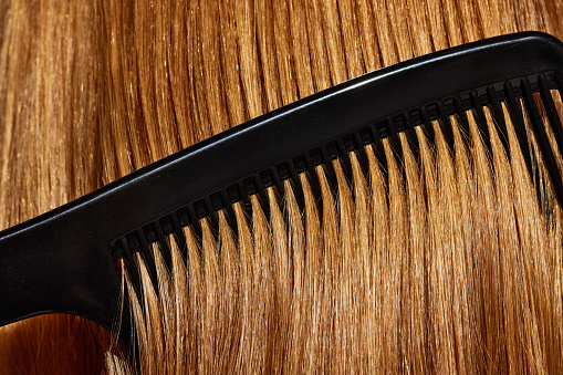 Close-up image blonde female hair and hair brush. Taking care after look, straight hair. Haircut. Concept of beauty, hair care, treatment, natural cosmetics. Copy space for ad