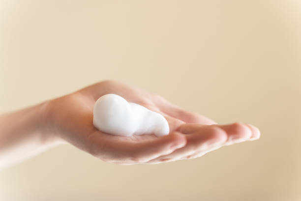 istock Young woman's hand, holding lathering soap or face wash foam 1783578347