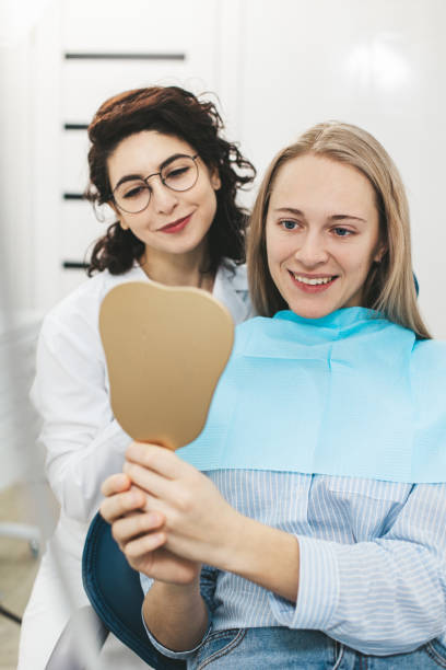 istock Dentist and patient smiling while looking in the mirror in dental clinic 1783579097