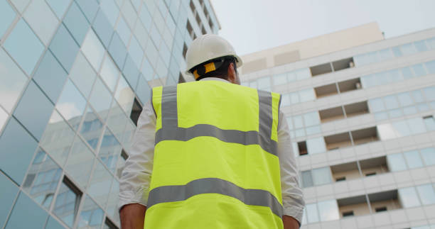 istock Low angle rear view of engineer looking up at modern building outdoors 1783579650