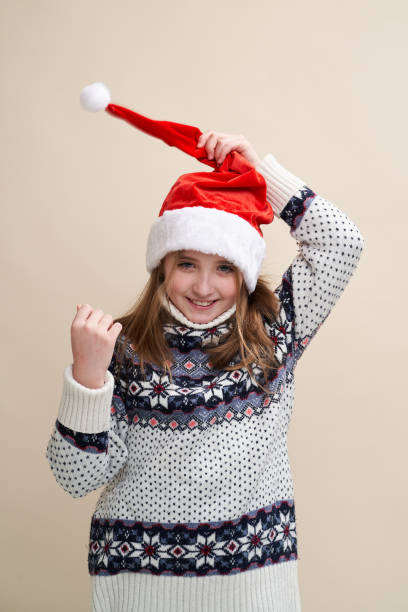 Funny cute girl holds Santa's hat on her head stock photo