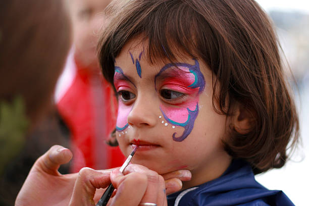 bambina avendo il viso dipinto - pittura per il viso foto e immagini stock