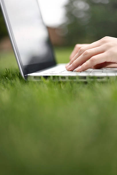 Working on a laptop in the grass