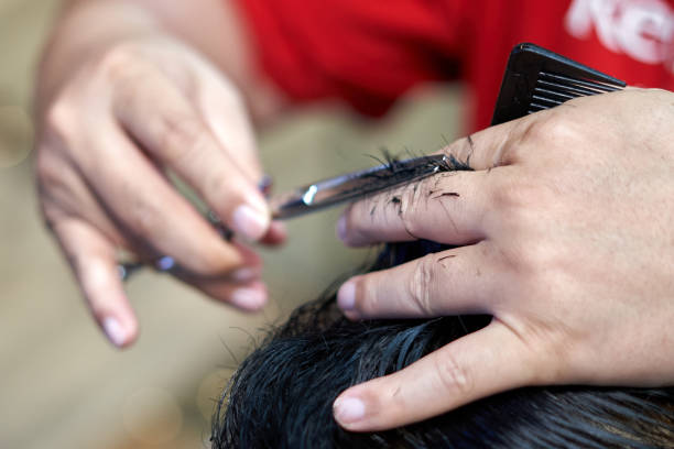 istock Barber cutting the hair of a male using scissors 1783590302