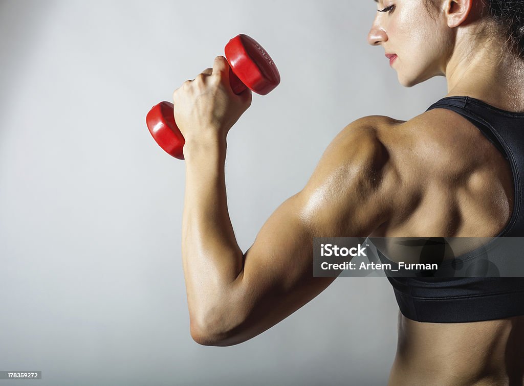 Fitness woman Fitness woman with barbells on grey background Active Lifestyle Stock Photo