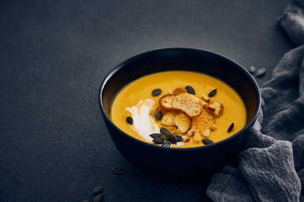 istock Pumpkin cream soup with croutons on dark background 1783599143