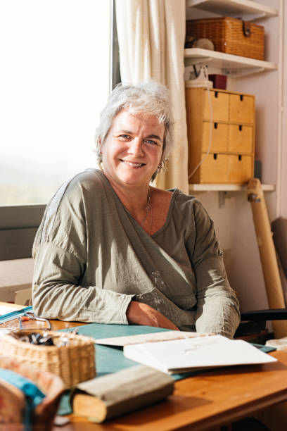istock Happy aged woman sitting at her studio with handmade notebook in daylight 1783604166