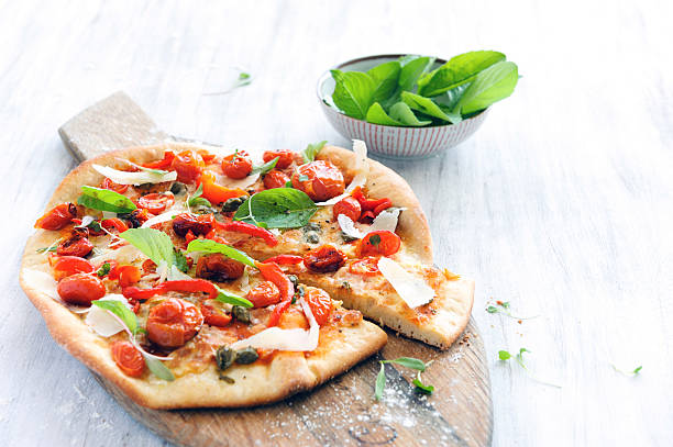 Gourmet delicious pizza Fresh, handmade pizza with oven roasted tomatoes, peppers, capers, basil and shaved cheese flatbread stock pictures, royalty-free photos & images