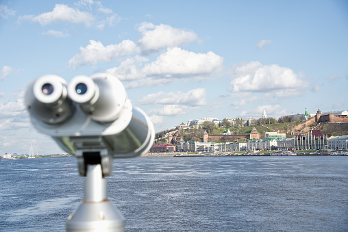 The telescope stands on the bank of River. The pipe is in focus, and the shore opposite is out of focus.