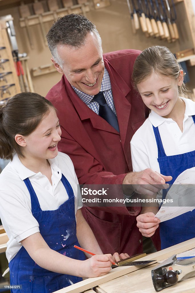 Schoolgirls y maestro en clase de carpintería - Foto de stock de Carpintería libre de derechos