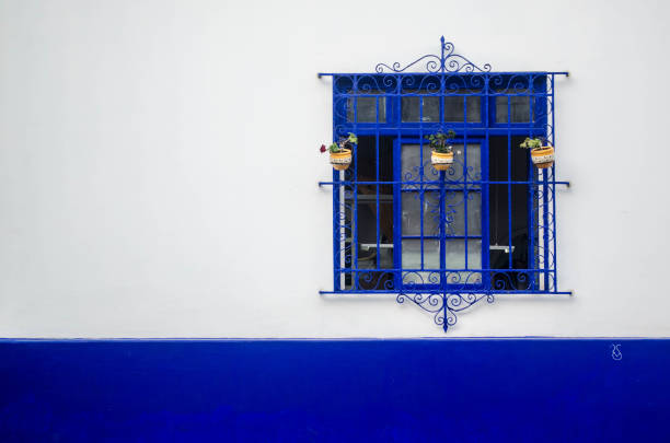 istock An ornate window painted blue against a vibrant white and blue wall 1783613208