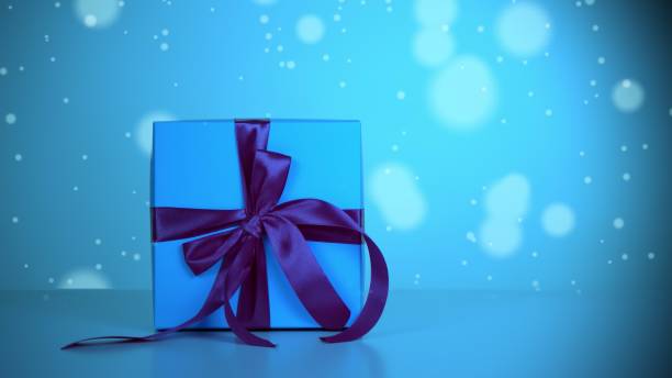 istock wrapped gift. close-up. light blue gift box with dark blue ribbon. light blue bokeh background with a slight shimmer. 1783618890