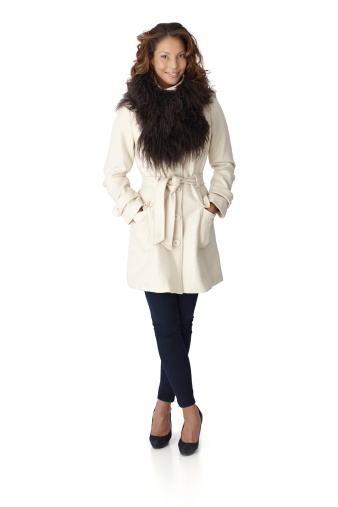 Full size autumn portrait of pretty young woman in white coat with fur around neck.