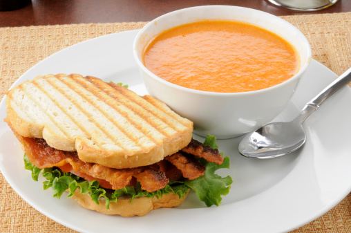 A grilled bacon, lettuce tomato panini with tomato bisque soup