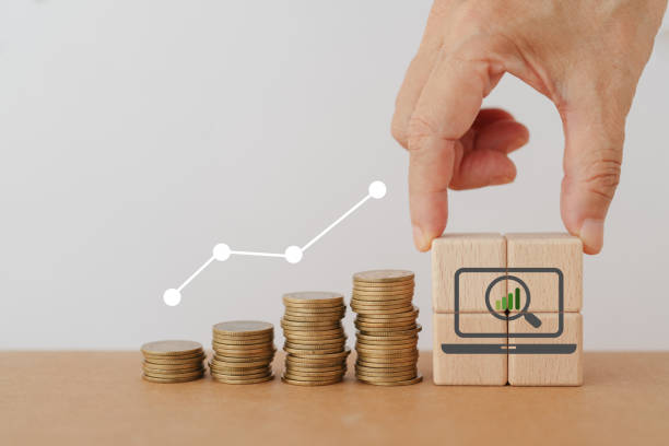 istock Search, Research, Finding Solution, Investigate Concept. Hand arranged wooden cube blocks with magnifying glass inside computer icon, and stack of coins. For marketing research. Customer insight. SEO 1783628259
