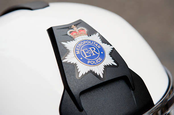Police Helmet Close up of a Metropolitan Police crash helmet.Point of focus is on the police badge. metropolitan police stock pictures, royalty-free photos & images