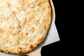 Delicious pizza Quattro formaggi with cheddar, parmesan, mozzarella and blue cheese isolated on black