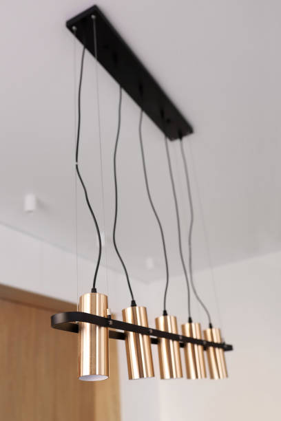 istock Decorative modern chandelier hanging on the ceiling over table in modern white room. Pendant Sconce Lighting Lamp. Modern interior design 1783642894